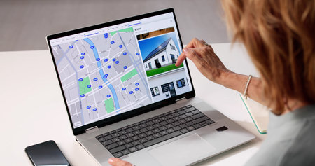 Senior Real Estate Agent Helps Woman Navigate Online Property Searchの写真素材