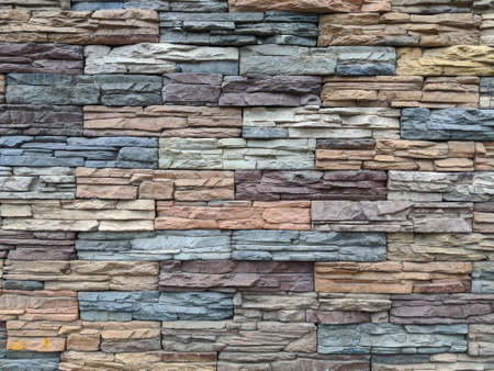Multi-colored masonry: the wall of the house is made of decorative stone. Beautiful background for design and bannersの写真素材