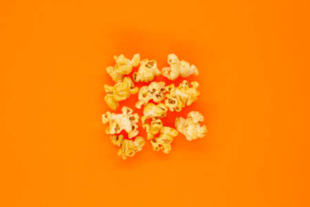Sweet popcorn on an orange background close-up top viewの写真素材