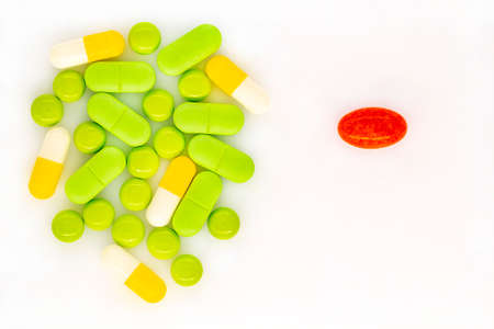 A lot of multi-colored medical pills top view close-up isolated on a white background. Vertical...