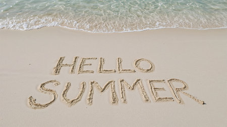 Image is a landscape-style photograph capturing a sandy beach with gentle ocean waves lapping at the shore. The sand is light beige, and the water is a soft blue with white foam. In the foreground, the words 'HELLO SUMMER' are written in the sand in uppercase letters. The text appears to be hand-drawn, with slightly uneven lines, giving it a casual and playful appearance. The overall composition conveys a relaxed and inviting summer atmosphere, with the contrast between the smooth sand and the textured water adding visual interest.の素材