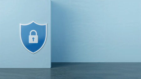 Image features a minimalist and modern style, depicting a large shield emblem on the left side of the frame. The shield is predominantly blue with a white border, and prominently displays a white padlock icon in the center, symbolizing security and protection. The background is a smooth, gradient light blue wall, creating a clean and professional atmosphere. The floor is a dark gray, adding contrast to the overall composition. The layout is simple, with the shield slightly off-center, drawing attention to the security theme without any additional text or logos present.の素材