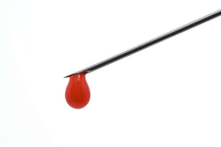 Needle of syringe with blood drop. Isolated over whiteの写真素材