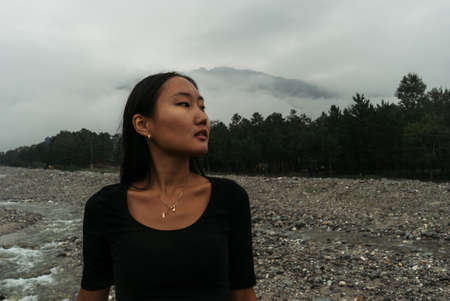 Girl in blue jeans in front of big waterfallの写真素材