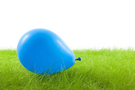 blue balloon on the grass, isolated on whiteの写真素材