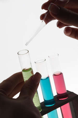 A researcher drip a solution into a test tube.