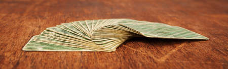 deck of playing cards expanded on fan shape on wooden tableの写真素材