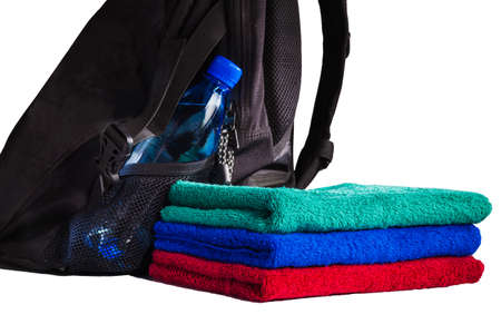 set of colorful towels and backpack with bottle of water isolated on white backgroundの写真素材