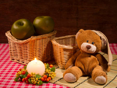 still life with bear, candle and applesの写真素材