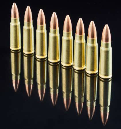 metal cartridges for hunting automatic weapons on a black background with a reflection