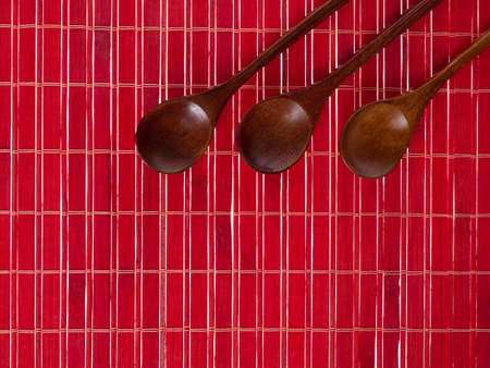 wooden spoons on a red backgroundの写真素材