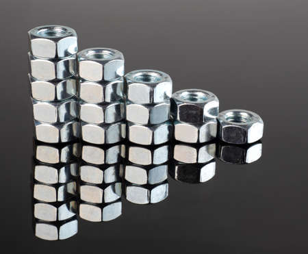 new shiny metal nuts on a mirrored black background