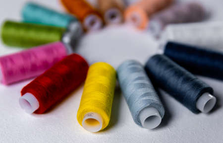 Colored thread for sewing. White background. Circle of spools of thread. Side view.