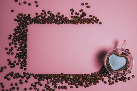 Background from coffee beans. Coffee texture. Place to write text. Cup with coffee in the corner of the frame.の写真素材
