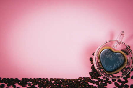 coffee cup of coffee and roasted arabica beans corner border formed on pink background with place for text.の写真素材
