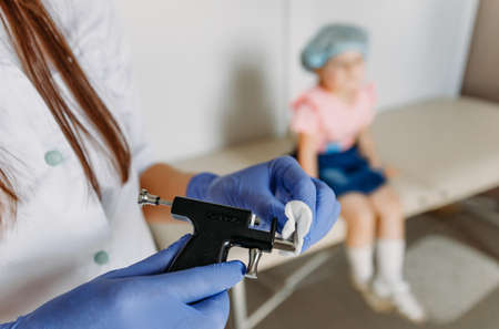 treating the pistol with an antiseptic before the ear piercing for a little girlの写真素材