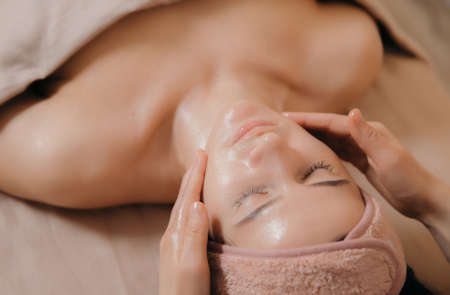 The girl makes a facial massage in a beauty clinic. View from above.の写真素材