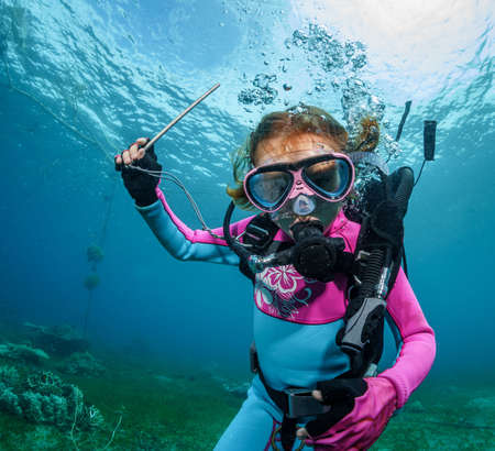 scuba diving child releases bubbles underwater in the oceanの写真素材