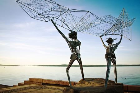 Sculpture of fishermen on the waterfront. throw a net in the sea.のeditorial素材