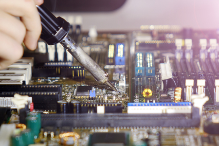 Soldering to a circuit Board of a computer close up.Electronic technology.の写真素材