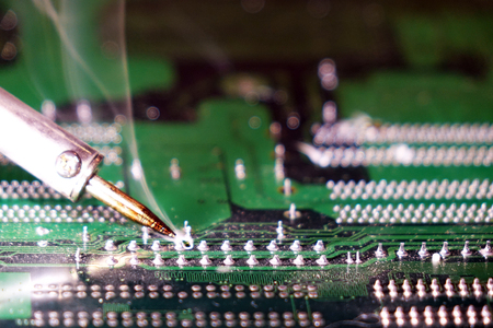 Soldering to a circuit Board of a computer close up.Electronic technology.の写真素材