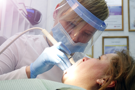 Dentist at work in the office. Treatment teeth.