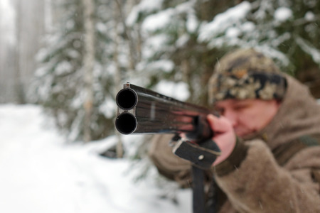 A hunter with a gun. Winter hunting. To aim at the target.Huntsman.の写真素材