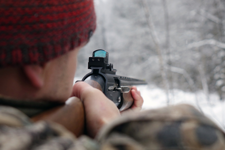 A hunter with a gun. Winter hunting. To aim at the target.Huntsman.の写真素材
