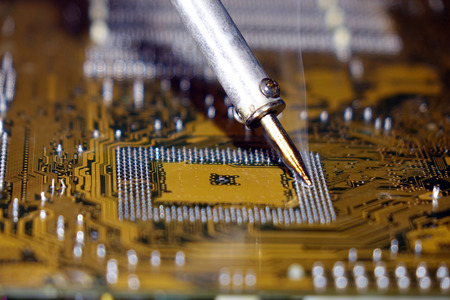 Soldering to a circuit Board of a computer close up.の写真素材