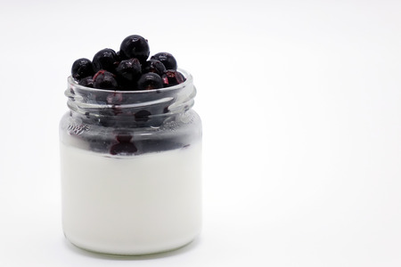 Fresh berries in the jar with the yogurt. On white background. Fruit yogurt.の写真素材