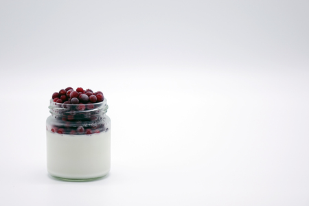 Fresh berries in the jar with the yogurt. On white background. Fruit yogurt.の写真素材