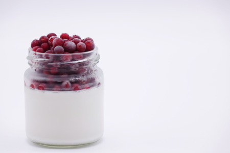 Fresh berries in the jar with the yogurt. On white background. Fruit yogurt.の写真素材