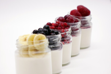 Fresh berries in the jar with the yogurt. On white background. Fruit yogurt.の写真素材
