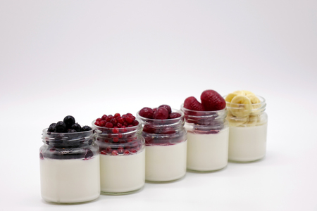 Fresh berries in the jar with the yogurt. On white background. Fruit yogurt.の写真素材