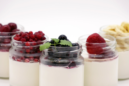 Fresh berries in the jar with the yogurt. On white background. Fruit yogurt.の写真素材