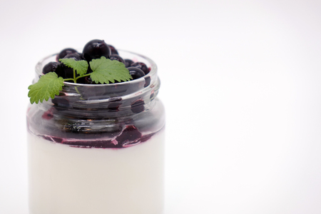 Fresh berries in the jar with the yogurt. On white background. Fruit yogurt.の写真素材