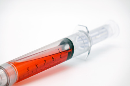 Syringe with blood isolated on white.Vaccination.の写真素材