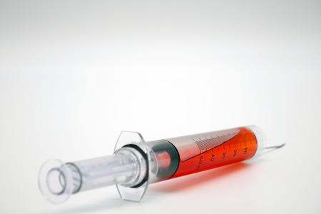 Syringe with blood isolated on white.Vaccination.の写真素材