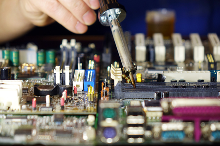 Soldering to a circuit Board of a computer close up.Electronic technology.の写真素材