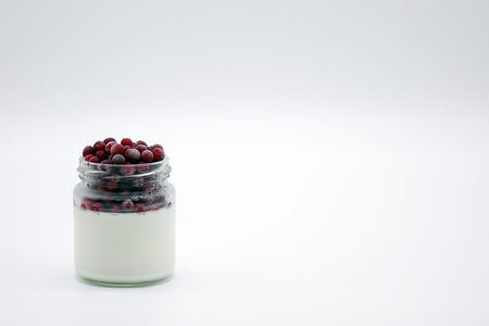Fresh berries in the jar with the yogurt. On white background. Fruit yogurt.の写真素材