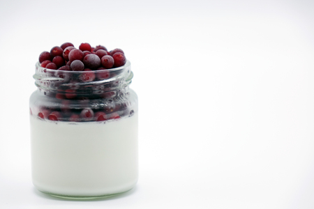 Fresh berries in the jar with the yogurt. On white background. Fruit yogurt.の写真素材