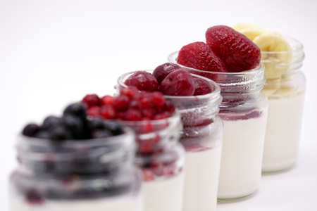 Fresh berries in the jar with the yogurt. On white background.の写真素材