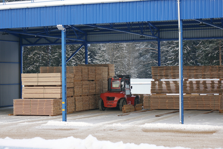 The machine picks up the lumber at the woodworking factory.Lumber warehouse.の写真素材