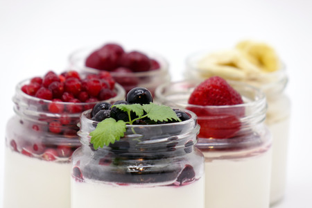 Fresh berries in the jar with the yogurt. On white background. Fruit yogurt.の写真素材