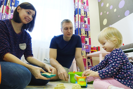A young family plays at home with a childの写真素材