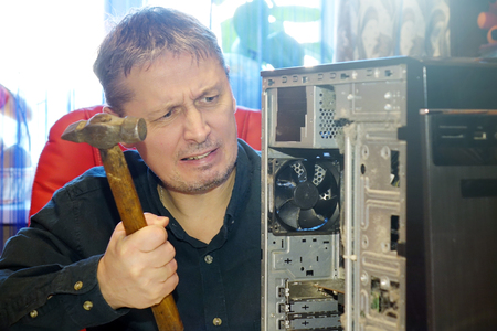 Repair of computers at home. The man works on a broken console .の写真素材