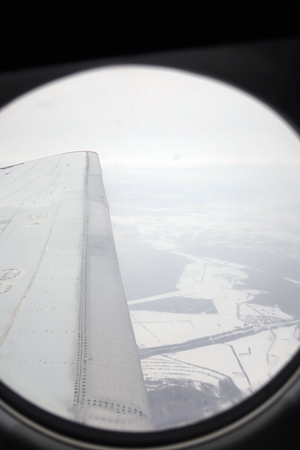 Airplane wing.Clouds and sky as seen through the window of the aircraft.の写真素材