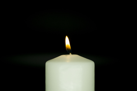 Candle on isolated black background. memoryの写真素材