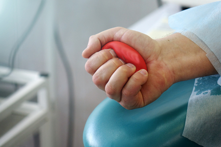 Red heart in the hands of the donor. Transfusion of donor blood.の写真素材