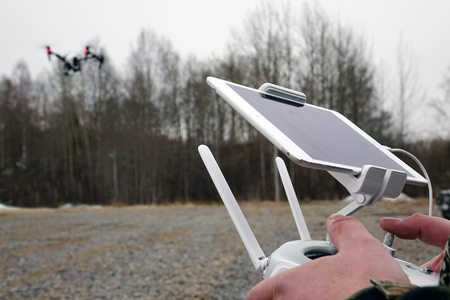 Drone remote control in hand man.Man operating of flying droneの写真素材